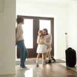 Little kid girl embracing dad leaving family moving out with travel case
